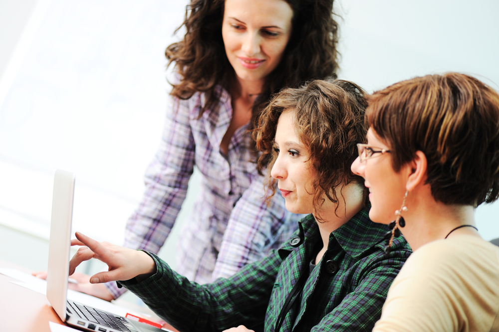 While  meeting, group of young women working together on the table